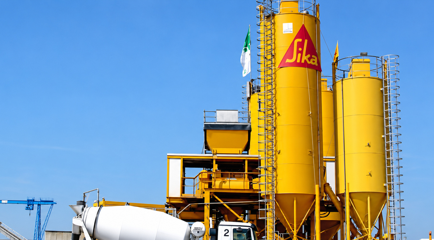 Installation industrielle Sika avec un grand silo jaune et ses équipements techniques